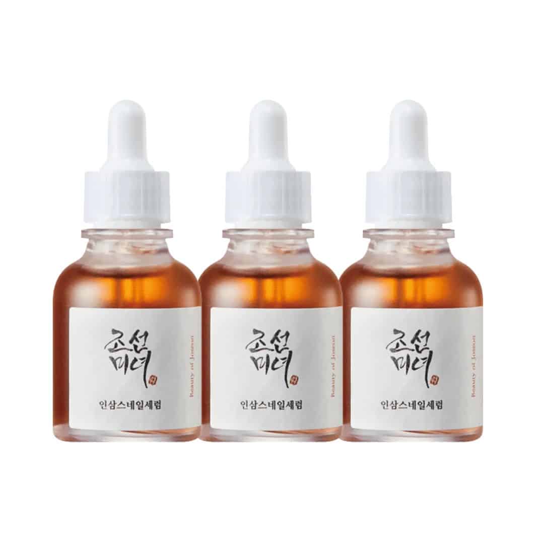 Three bottles of a skincare serum with white droppers on a white background