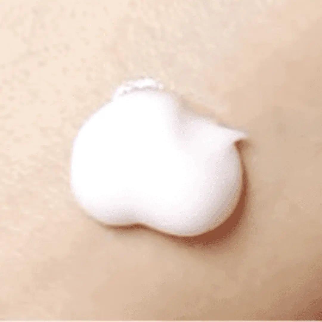 White cream being applied to a beige surface