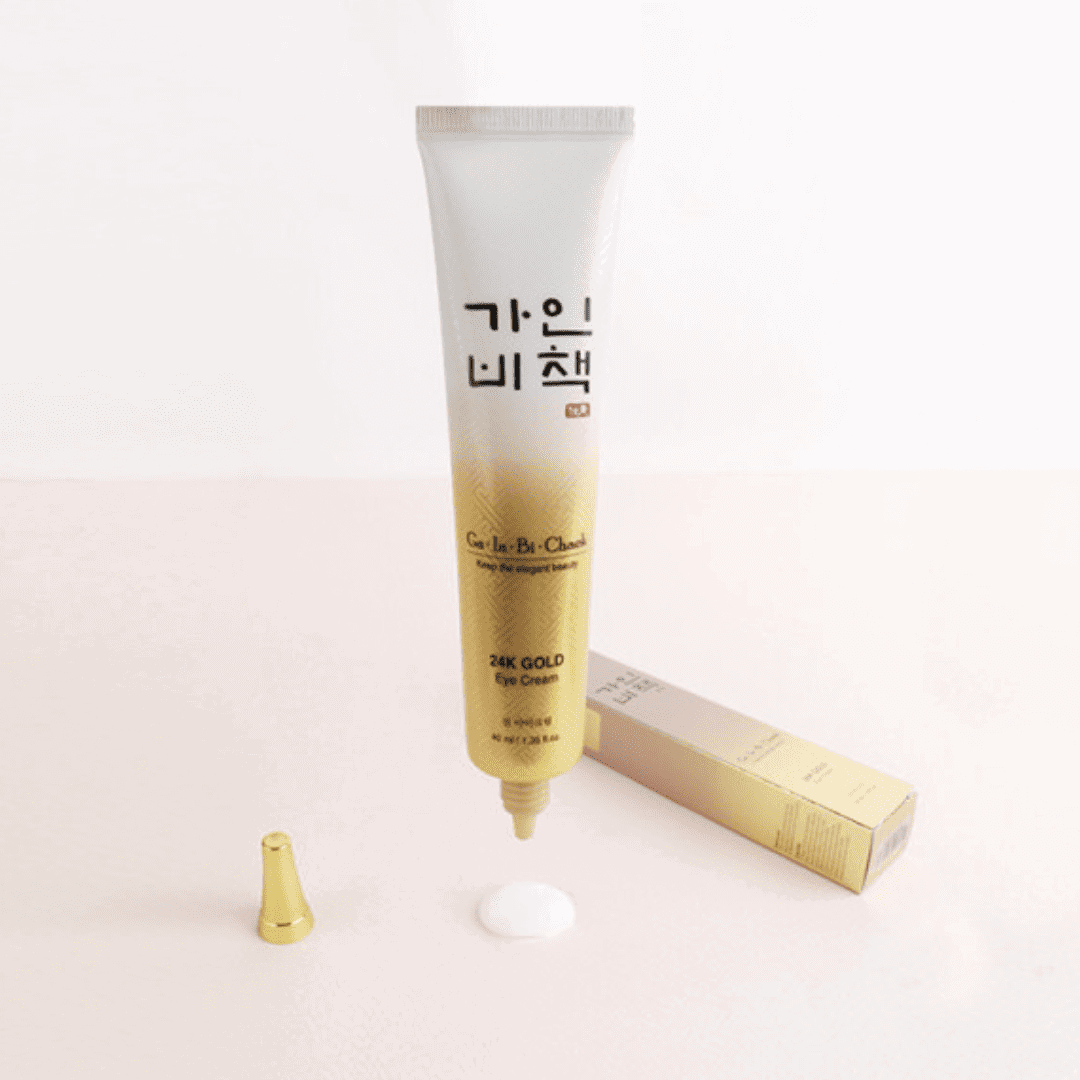 Gold eye cream tube with packaging on a white background